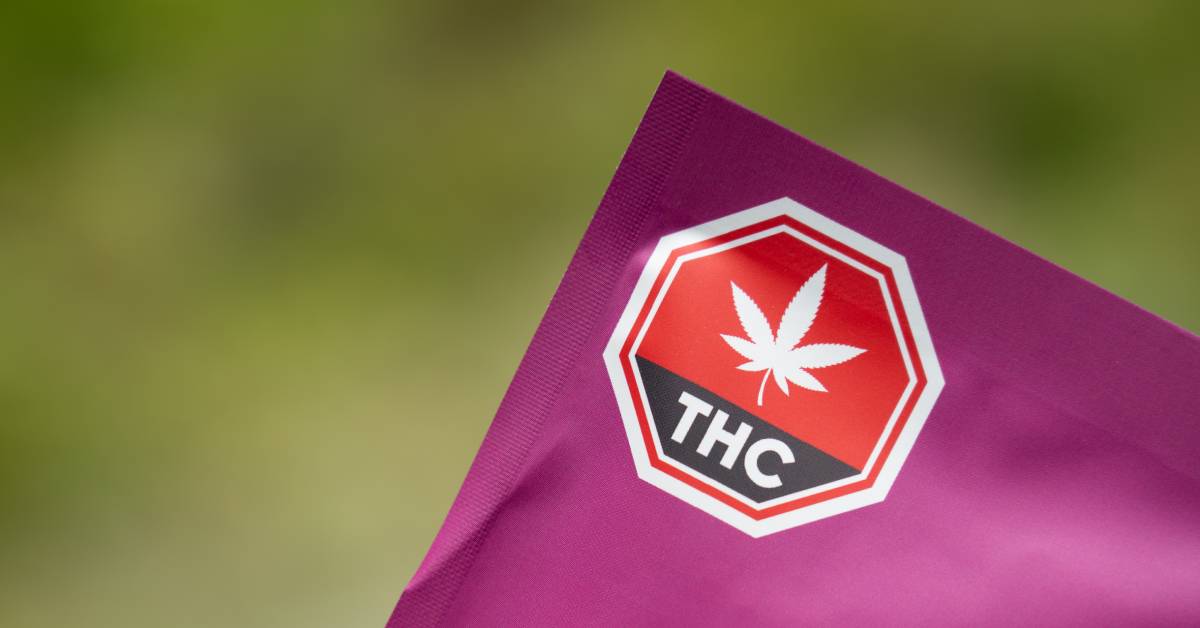 A purple package with a red "THC" label on the left corner. The package also has an image of a cannabis leaf.